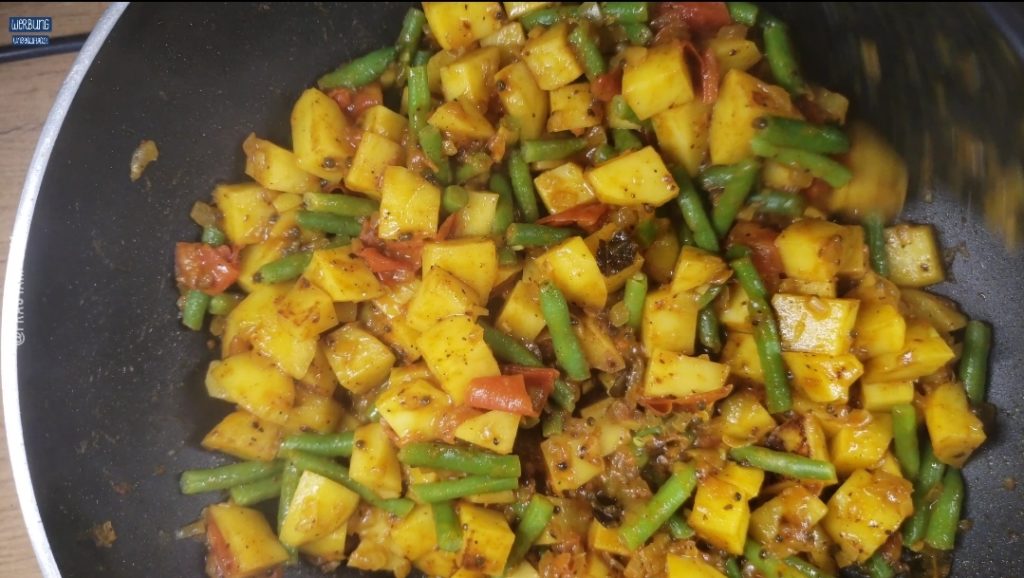 Grüne Bohnen dem Curry zufügen und salzen.